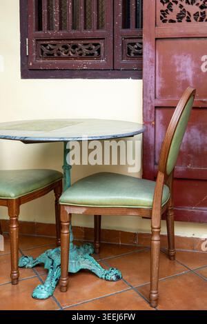 An outdoor dining table and chairs outside a cafe in George Town, Penang, Malaysia. Stock Photo