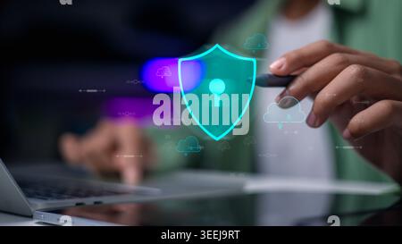 Hand using laptop with virtual shield and cloud icons. Cyber security, data storage protection, cloud computing safety, and network encryption technol Stock Photo