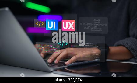Developer hand using laptop with UI UX design and coding icons. Concept of user experience, web development, software programming, and digital interfa Stock Photo