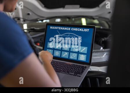 Mechanic communicating with a customer, using digital tools, a laptop for vehicle maintenance in front of a car with the hood open. Stock Photo