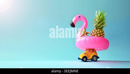 Pink inflatable flamingo on toy car and pineapple. Summer pool float party idea. Summer concept Stock Photo