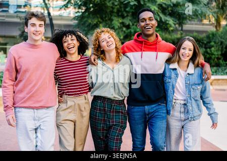Group of young friends walking together outdoors Stock Photo