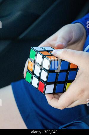 Close up of Children s Hands Solving Rubiks Cube. Vertical photo. Stock Photo