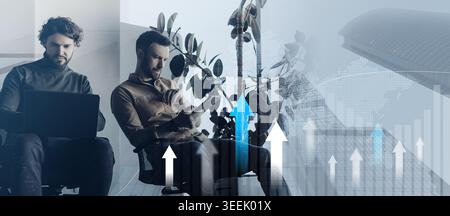 Serious male colleagues working together, using laptop computer and digital tablet at contemporary company office Stock Photo