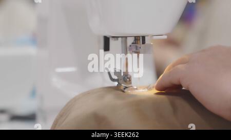 Sewing machine close up while stitching fabric in a tailor shop in professional  Stock Photo
