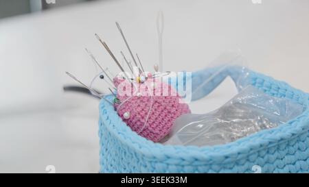 Pin cushion with needles while standing on table for sewing work in professional Stock Photo