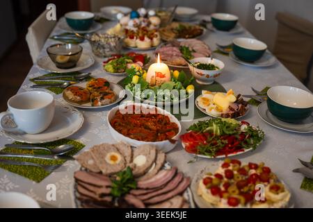 Traditional Easter festive table setting with eggs, zurek soup, and various dishes for a holiday breakfast celebration in Poland. Stock Photo