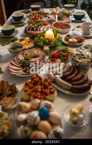Traditional Easter festive table setting with eggs, zurek soup, and various dishes for a holiday breakfast celebration in Poland. Stock Photo