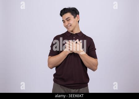 Man holding heart gesture - placing hands on chest with love emotion Stock Photo