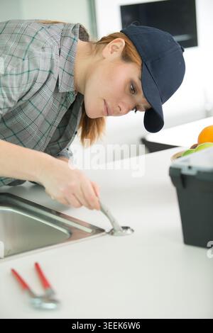 female plumber working on sink Stock Photo