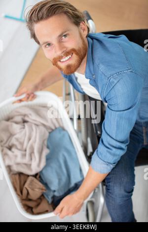disabled man in wheelchair doing laundry Stock Photo