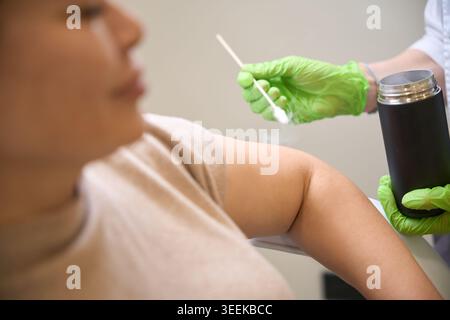 Healthcare professional treating patient in medical office Stock Photo