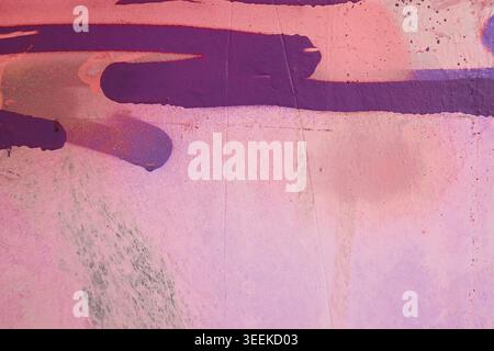 Messy purple paint strokes on an old dirty pink wall background, abstract grunge texture with rough brush marks and distressed surface Stock Photo