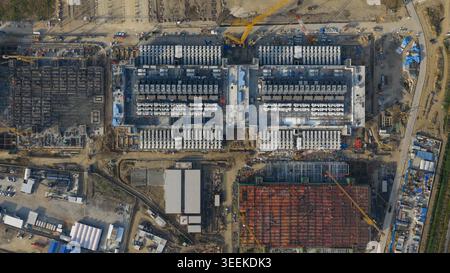 Aerial view of Bridge Data Center under construction showing industrial structures, cooling systems, and yellow cranes on a large site Khlong Tamru, C Stock Photo