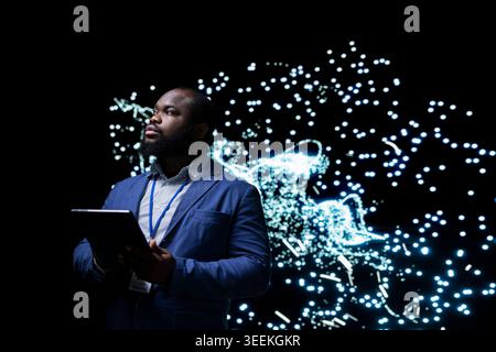 Implementing AI algorithms, tablet app and software developer creating deep learning system. Building neural network architecture, device and African american man using artificial intelligence Stock Photo