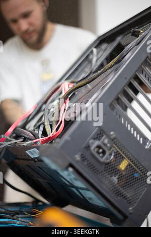 Technician works on computer hardware in a workshop in the afternoon Stock Photo