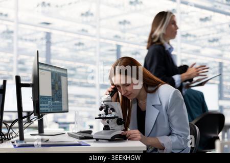 Close up of engineers inspecting silicon wafer substrates at office desk in industrial plant research facility. Hardware manufacturing factory employees analyzing colorful semiconductor slice Stock Photo