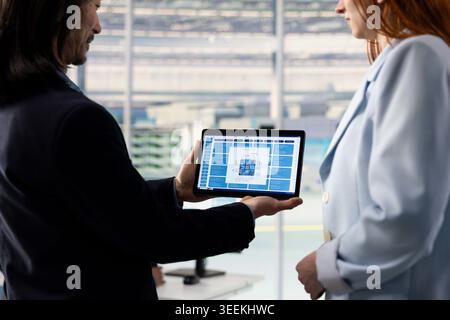 Designing energy efficient semiconductors, tablet and engineering team using sustainable technology. Upgrading microchip hardware production, device and teamworking colleagues Stock Photo