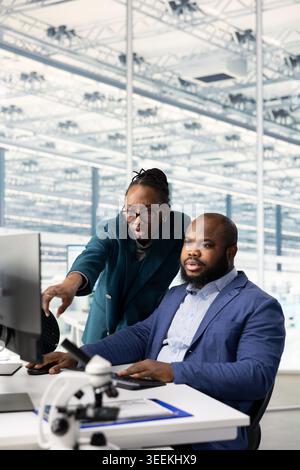 Working together, microchip manufacturing and technicians in RD office conducting study on SoC architecture design. Developing innovative technology, semiconductors and African american coworkers Stock Photo