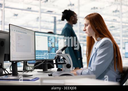 Analyzing integrated circuit, laboratory microscope and woman working in microchip factory RD office at workstation. Inspecting PCB parts, optical equipment and scientist in research facility Stock Photo