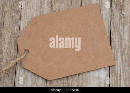 Blank brown kraft paper tag on rustic wood desk, for your sale or promotion Stock Photo