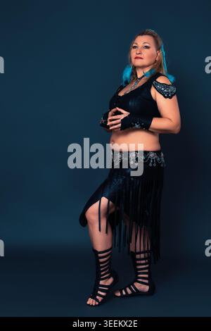 Full length portrait of woman in black handmade leather outfit - performance costume designed and crafted by hand. Women's costume includes leather to Stock Photo