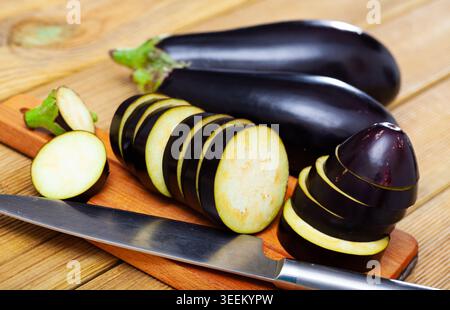 Sliced aubergine on wooden table Stock Photo