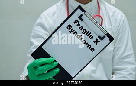 Doctor holds in hands a clipboard with the name of the fragile X syndrome. Medical concept Stock Photo