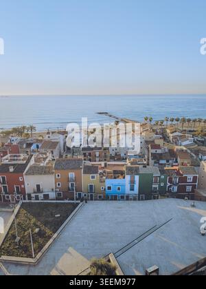 Aerial view of the iconic colorful houses along the Mediterranean coast with a sandy beach and palm trees in La Vila Joiosa, Valencian Community, Spai Stock Photo