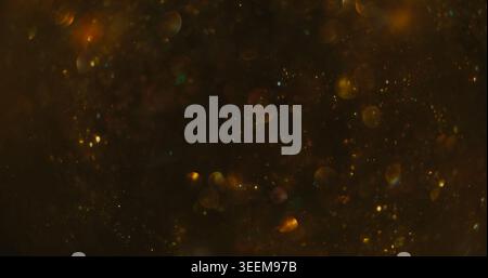 Confetti texture blur. Color bokeh blink. Golden shimmering snow stream on dark abstract background. Night circles reflection mix. Stock Photo