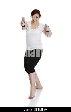 Young woman during fitness time and exercising with dumbbells, isolated on white background Stock Photo