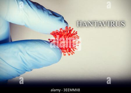 Doctor wearing blue medical gloves holding a glowing hantavirus symbol in hand, concept image for viral infection, epidemiology, healthcare alert, pan Stock Photo