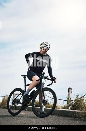 Person, cyclist and back pain with bicycle outdoor for bad posture, discomfort or health strain. Fitness, cycling and man with sore muscle, bike Stock Photo