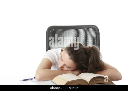Young caucasian student woman sleeping on the desk with book Stock Photo