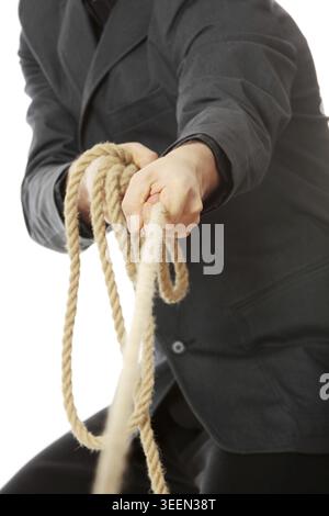 Businessman pulling on a rope. Isolated on white Stock Photo