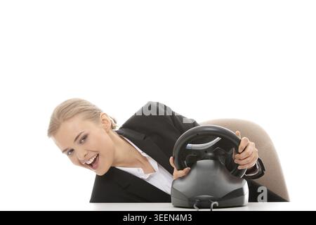 Young caucasian business woman playing on computer (with steering wheel), isolated on white background Stock Photo