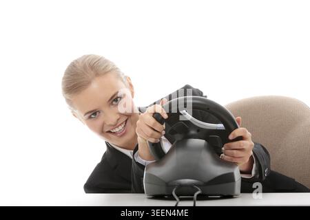 Young caucasian business woman playing on computer (with steering wheel), isolated on white background Stock Photo