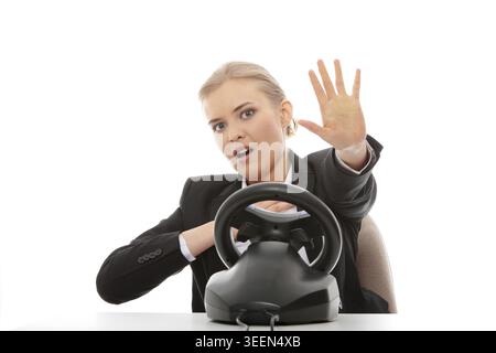 Young caucasian business woman playing on computer (with steering wheel), isolated on white background Stock Photo
