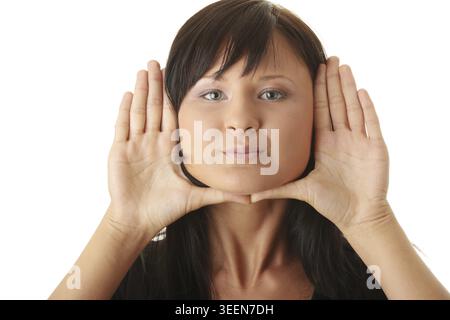 Young woman, framing her face with her hands Stock Photo