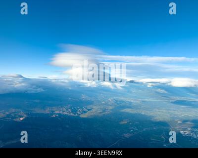 Expansive aerial landscape with dramatic lenticular cloud above distant mountains and valleys Stock Photo
