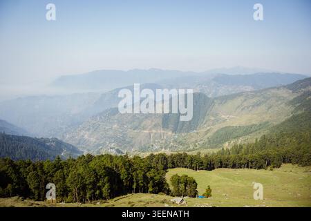 Panoramic view of layered mountain ridges and pine forests at Raghupur Fort, Sojha, Manali, Himachal Pradesh, India. Stock Photo