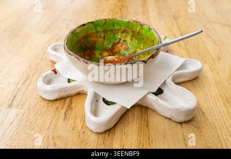 Dirty Plate, Dirty Dishes, Empty Bowl after Dinner, Finished Lunch with Soup Leftovers, Smeared Cream on White Plate on Wood Table Background Stock Photo