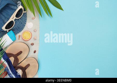 Beach vacation summer holiday flat lay with flip flops and sunglasses on blue background Stock Photo
