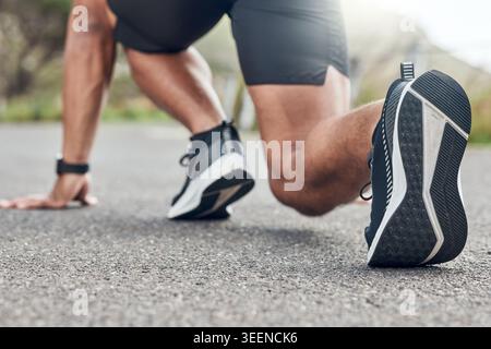 Runner, ready and shoes with man in nature for fitness workout, race practice and start position. Wellness, training and begin with feet of person Stock Photo