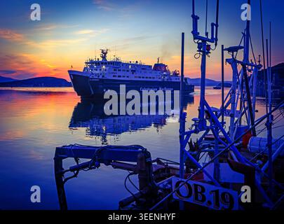 CalMac MV Clansman in Oban harbour at dusk, illustrating ferry disruption and lifeline service reliability for Scottish islands Stock Photo