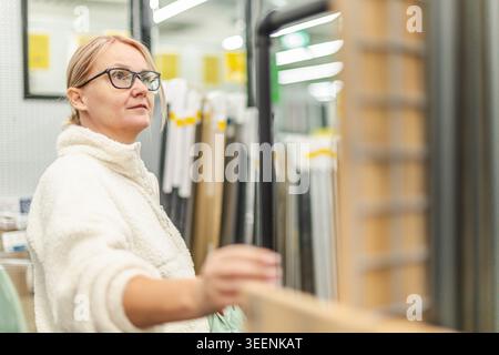 Woman browsing home renovation materials in hardware store interior Stock Photo