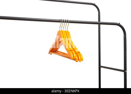 Stack of orange hangers hanging on black metal rack corner. Plastic garment holders gathered on horizontal rail. Minimal interior scene for wardrobe, Stock Photo