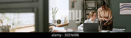Businesswomen Collaborating on Digital Project in Modern Office Stock Photo