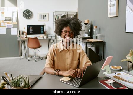 Portrait of Black Woman Working on Laptop in Modern Office Stock Photo