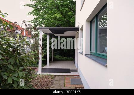 The minimalist entrance of Haus Rabe in Zwenkau, a Bauhaus modernist masterpiece featuring an illuminated glass door and sleek canopy Stock Photo